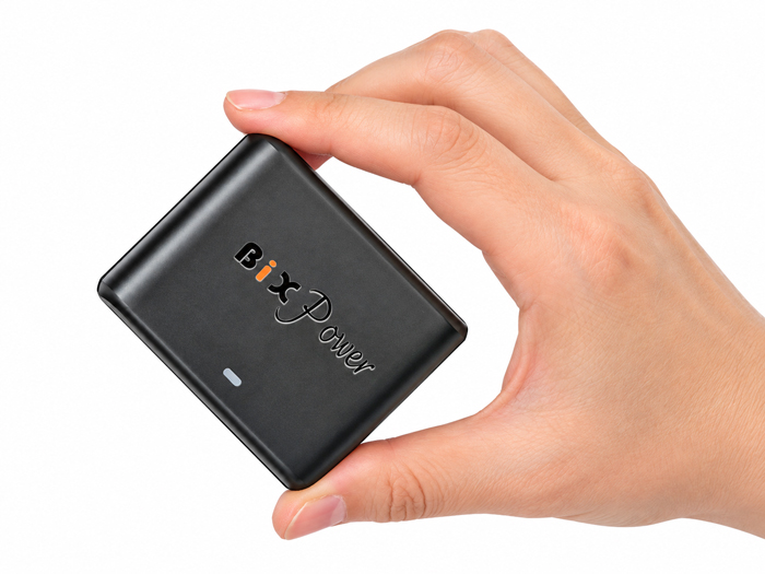 Compact BiXPower 90W DC converter held in hand showing small size and lightweight design