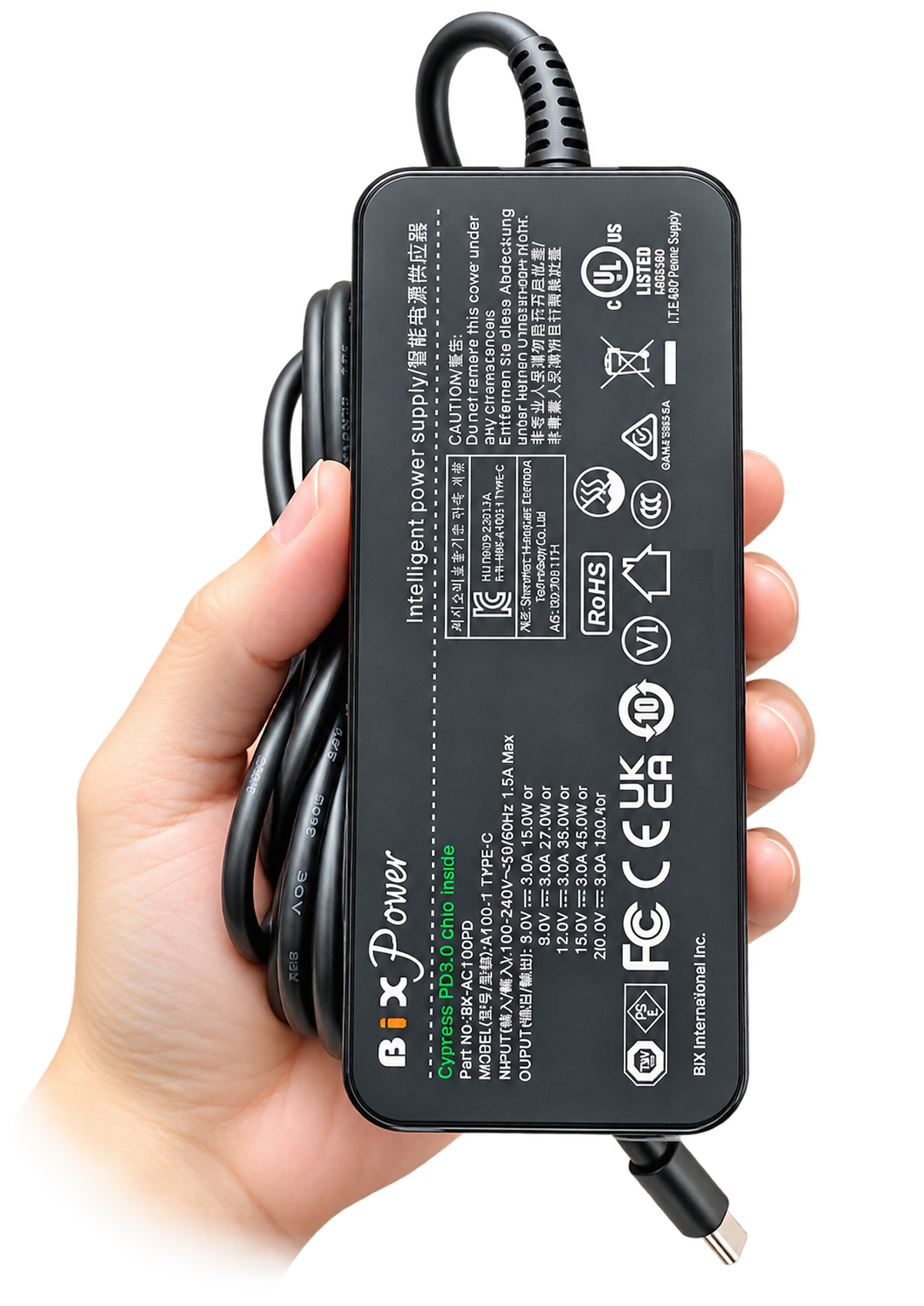 Hand holding BiXPower BX-AC100PD 100W USB-C laptop charger showing product label and safety certification markings